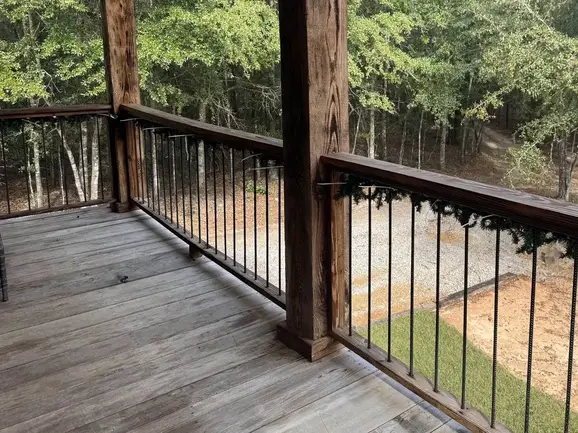 A porch with handcrafted railing and exposed log beams
